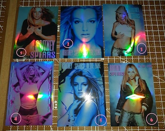 May include: Six collectible cards featuring Britney Spears. The cards have a holographic effect with images of the singer in various poses. The text "Britney Spears" and "In The Zone" are visible on some cards.