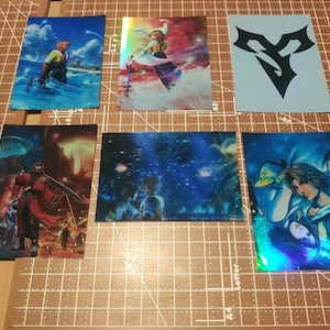 May include: Six holographic trading cards featuring characters from the Final Fantasy video game series. The cards are blue, green, and purple with a silver shimmer. The cards feature characters from the Final Fantasy VII and Final Fantasy VIII games. The cards are in a protective sleeve.