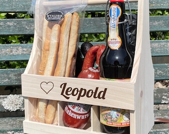 May include: A wooden crate with a handle, personalized with the name "Leopold" and a heart. The crate contains a bottle of beer, breadsticks, and sausage.