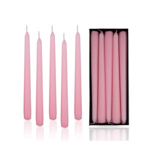 May include: A box of six pink taper candles. The candles are long and slender, and they are arranged in a row in the box.