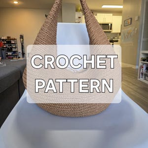 May include: A two-tone crocheted bag with a rounded base and a curved handle. The bottom is light beige, while the top and handle are a darker tan colour. The text "CROCHET PATTERN" is displayed across the bag.