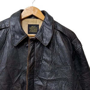 May include: A vintage brown leather Type A-2 bomber jacket with a collared neckline and a small pocket. The jacket is hanging on a wooden hanger. The text on the label reads "TYPE A-2" and "U.S. AIR FORCES".