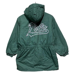 Pu&ograve; includere: Giacca con cappuccio verde scuro con la scritta "Polo" in bianco e la parola "Basketball" sotto. La giacca ha una vita con coulisse e maniche lunghe. La giacca &egrave; realizzata in materiale trapuntato.