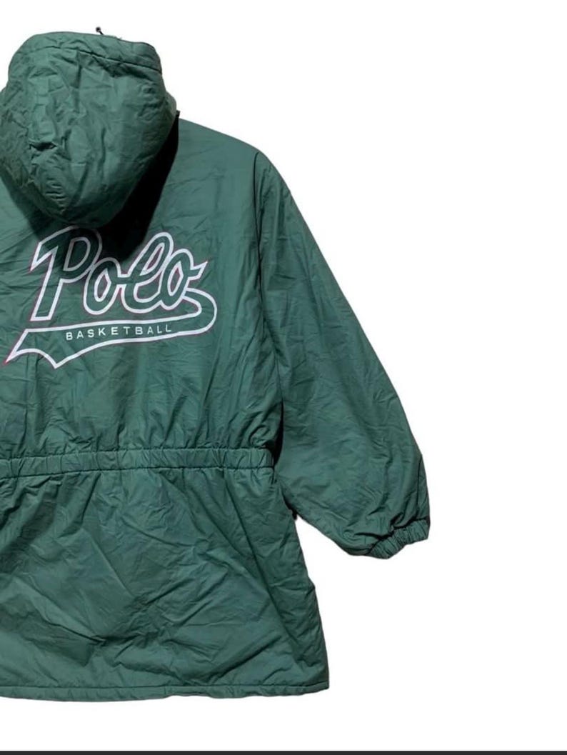 Pu&ograve; includere: Giacca con cappuccio verde scuro con la scritta "Polo" in corsivo bianco e la scritta "Basketball" sotto. La giacca ha una vita con coulisse e una cerniera a tutta lunghezza. La giacca &egrave; realizzata in un materiale leggero.