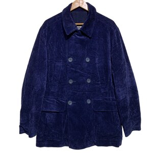 May include: A dark blue corduroy double-breasted jacket with two large pockets on the front.