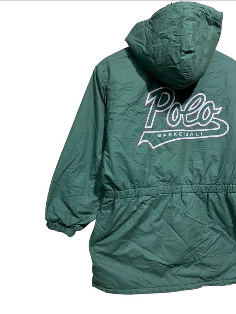 Pu&ograve; includere: Giacca con cappuccio verde con la scritta "Polo BASKETBALL" in bianco. La giacca ha una vita con coulisse e polsini elasticizzati. La giacca &egrave; realizzata in materiale trapuntato.