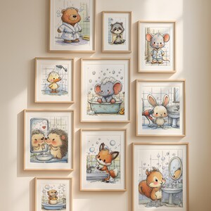 May include: A collection of framed watercolor prints featuring adorable animals in bathroom settings. The artwork includes a bear in a robe, a raccoon in a towel, a mouse in pajamas, a duck in the shower, and an elephant in a bathtub.