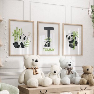May include: Three framed prints with watercolor illustrations of pandas and bamboo. The middle print features the letter T and the name Tommy. Three plush teddy bears are sitting in front of the prints.