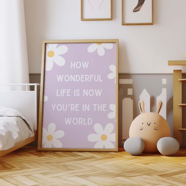 May include: A framed print with a light purple background and white daisies. The print features the text "How Wonderful Life Is Now You're In The World".