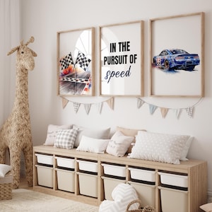 May include: Three framed prints with racing themes. One shows checkered flags, another reads "IN THE PURSUIT OF speed", and the last depicts a blue race car. A woven giraffe and storage unit with bins complete the room.