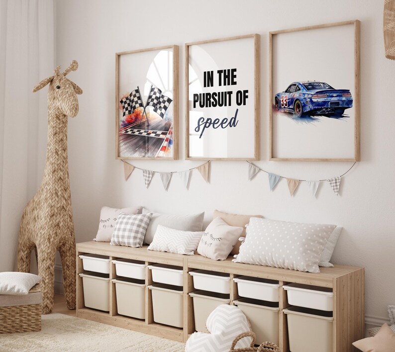 May include: Three framed prints with racing themes. One shows checkered flags, another reads "IN THE PURSUIT OF speed", and the last depicts a blue race car. A woven giraffe and storage unit with bins complete the room.