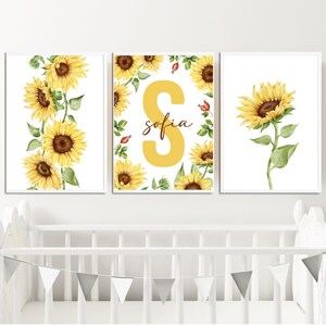 May include: Three framed prints with a sunflower theme. The center print features a large yellow letter "S" with the name "sofia" written in brown script. The left and right prints feature yellow sunflowers with green leaves on a white background.