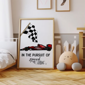 Może przedstawiać: Wydruk w ramie z czerwonym samochodem wyścigowym i szachownicą. Tekst brzmi "In the pursuit of speed".