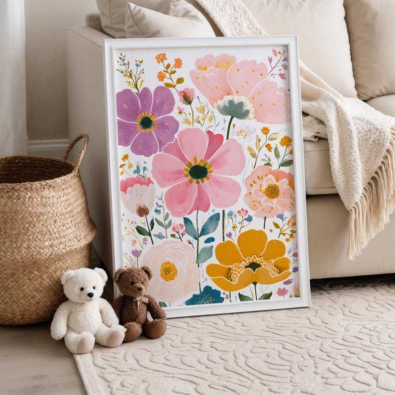 May include: A framed floral art print featuring a watercolor design of various flowers in shades of pink, purple, and yellow. The artwork is displayed in a white frame and is accompanied by two teddy bears and a woven basket.