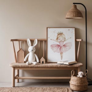 May include: A children's room scene featuring a wooden bench with a woven seat, a framed watercolor print of a ballerina, a white stuffed bunny, and a woven basket. A floor lamp with a woven shade and a small rug complete the decor.