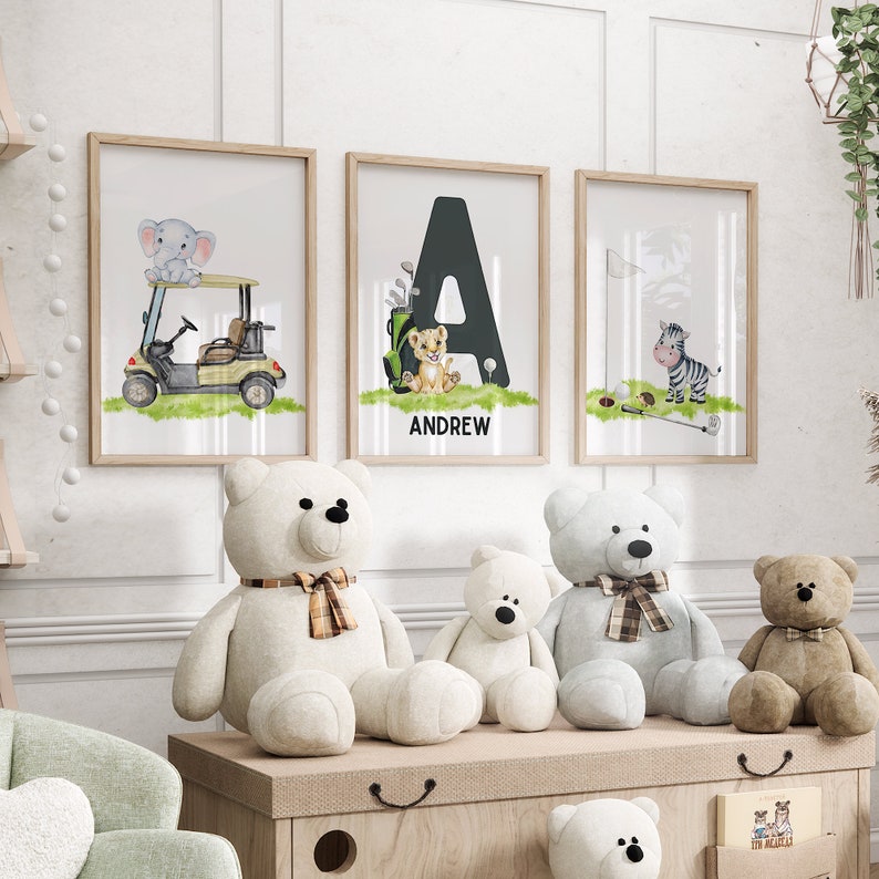 May include: Three framed prints with a golf theme. The prints feature a golf cart with an elephant, a lion with the letter A and the name Andrew, and a zebra with a golf club. There are four stuffed teddy bears in the image.