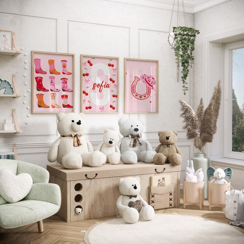 K&ouml;nnte beinhalten: Ein Kinderzimmer mit gerahmten rosa Wandbildern mit Cowboy-Stiefeln, der Zahl 8 mit dem Namen "Sofia" und einem Hufeisen mit einem Herz. Mehrere Teddyb&auml;ren unterschiedlicher Gr&ouml;&szlig;e sitzen auf einer Holzkiste. Ein hellgr&uuml;ner Sessel und dekorative Gegenst&auml;nde vervollst&auml;ndigen die Szene.