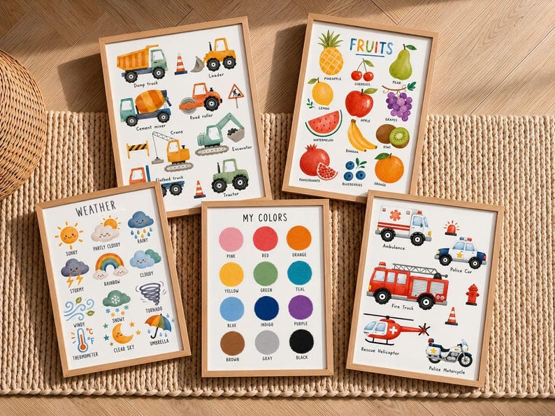 May include: A set of five educational wall art prints in light wood frames. The prints feature colorful illustrations of construction vehicles, various fruits labeled 'FRUITS', weather conditions labeled 'WEATHER', a color chart labeled 'MY COLORS', and emergency vehicles.