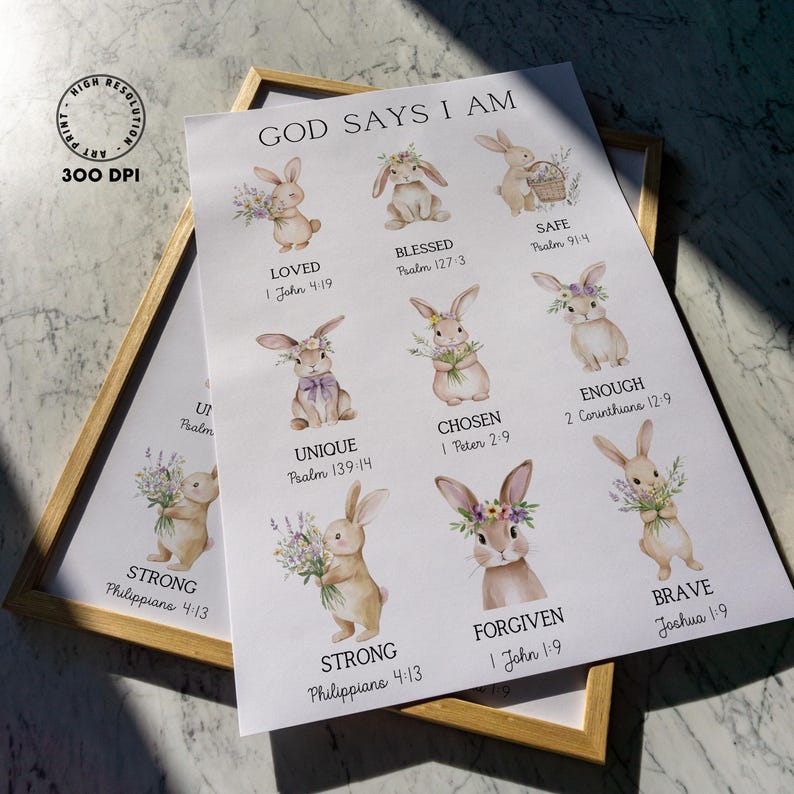 May include: A framed print with the text "GOD SAYS I AM" and illustrations of bunnies with floral accents. The print includes affirmations like "LOVED," "BLESSED," and "BRAVE," with corresponding Bible verses. The frame is a light brown color.
