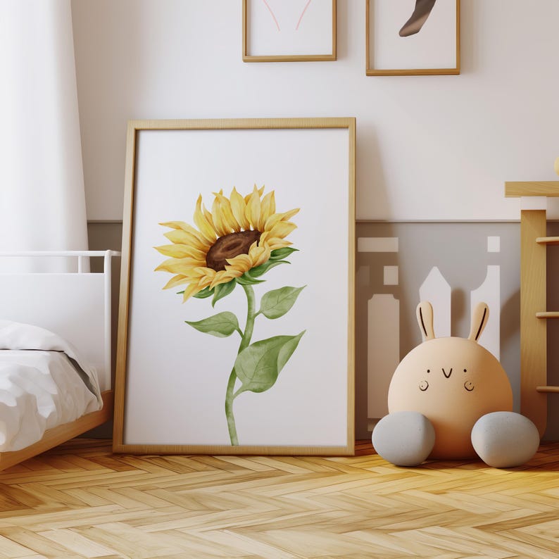 May include: A watercolor painting of a single sunflower with yellow petals and a brown center. The sunflower is on a white background and is framed in a light wood frame.