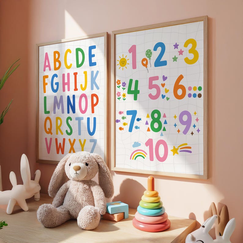 May include: Two framed educational posters with the alphabet and numbers 1-10 in bright colors. A plush bunny and a wooden stacking toy sit on a wooden surface in front of the posters. The posters are in a child's room.