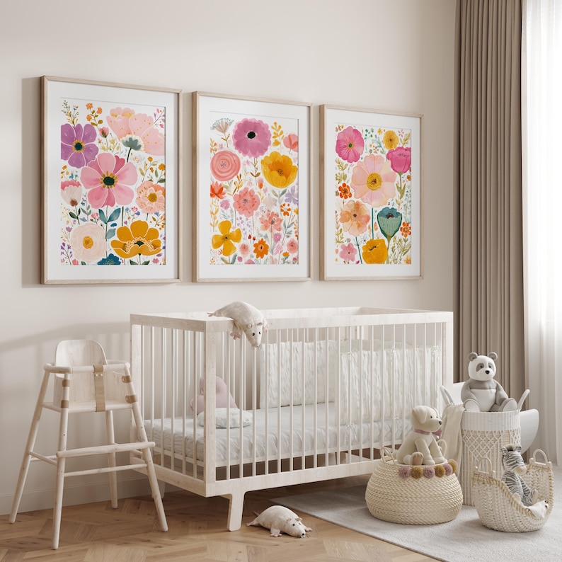 May include: Three framed floral art prints with colorful flowers in pink, yellow, and purple hues hang above a white crib. A high chair and decorative baskets with stuffed animals complete the nursery decor.