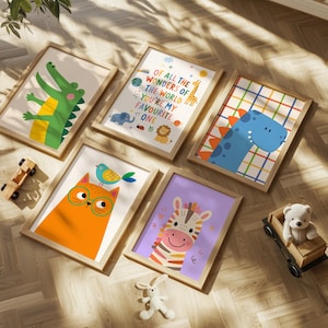 May include: A collection of framed art prints featuring colorful illustrations of animals and inspirational quotes. The artwork includes a green alligator, a blue dinosaur, an orange cat with glasses, and a smiling zebra. The text reads "Of all the wonders of the world, you're my favorite one."