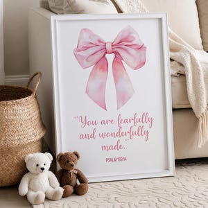 May include: White framed art print featuring a watercolor pink bow illustration. The print includes the text "You are fearfully and wonderfully made." and the Bible verse Psalm 139:14. Two teddy bears and a woven basket are in the foreground.