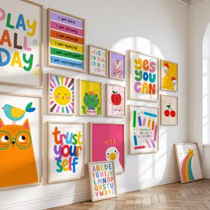 May include: A collection of framed art prints with colorful illustrations and motivational phrases. The prints feature a variety of images, including a sun, a frog, an apple, and a zebra. The words "Play All Day", "Yes You Can", and "Trust Yourself" are visible.
