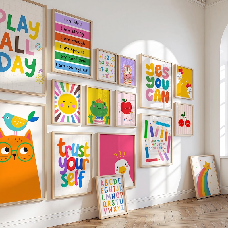 May include: A collection of framed art prints with colorful illustrations and motivational phrases. The prints feature a variety of images, including a sun, a frog, an apple, and a zebra. The words "Play All Day", "Yes You Can", and "Trust Yourself" are visible.