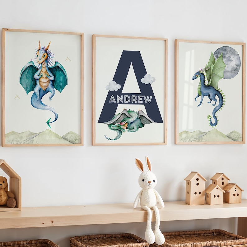 May include: Three framed prints featuring watercolor illustrations of blue dragons. The middle print has the letter A in navy blue with the name Andrew written below it.