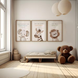 May include: Three framed prints with inspirational quotes and animal illustrations. The prints feature an elephant, a zebra, and a lion. The prints are hung on a white wall above a wooden bench. A brown teddy bear sits on the floor in front of the bench.