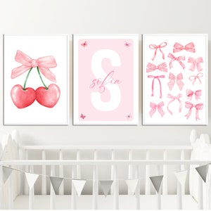 May include: Three pink and white nursery prints with a pink bow and cherries, a pink letter S with the name "sofia" and a collection of pink bows.