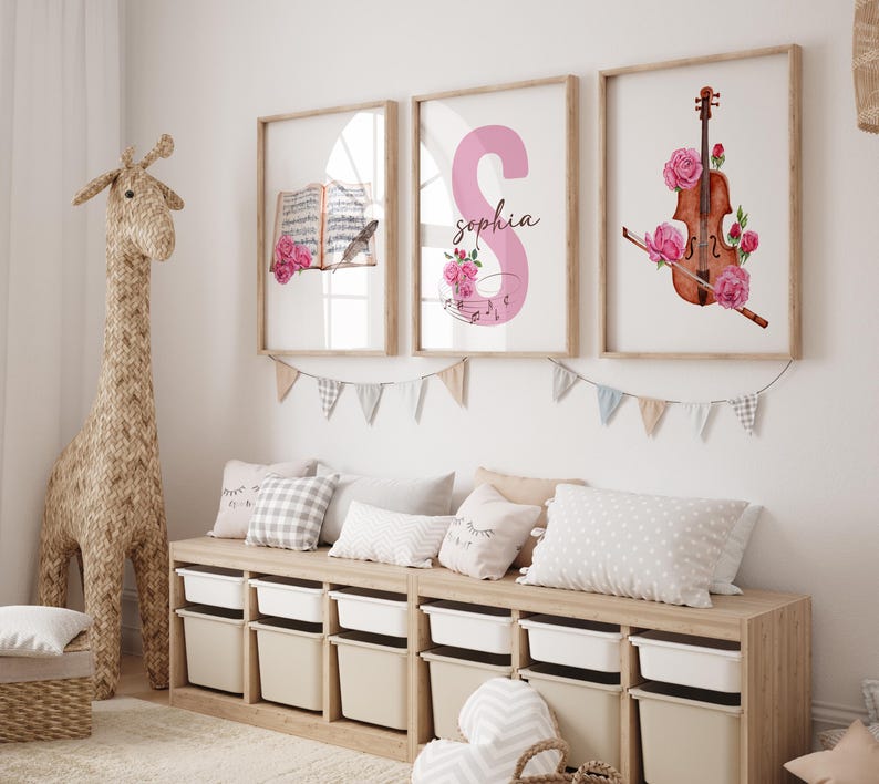 May include: Three framed prints with a pink floral theme. The first print features a book with musical notes and a pink rose. The second print features a pink letter "S" with the name "Sophia" and musical notes. The third print features a violin with pink roses.