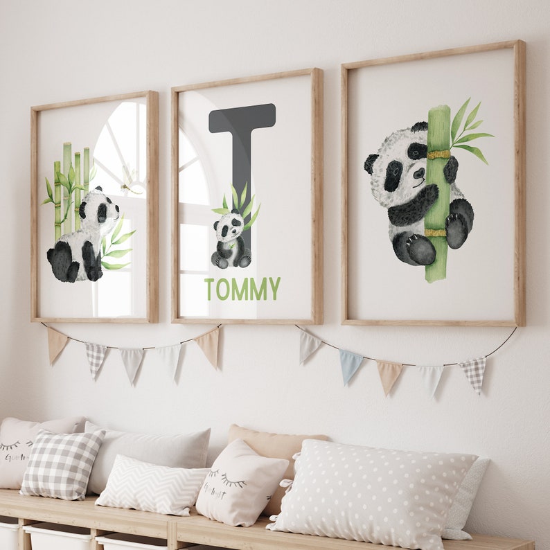 May include: Three framed prints with a watercolor illustration of a panda bear. The middle print features the letter T and the name Tommy. The print on the left shows a panda bear sitting next to bamboo. The print on the right shows a panda bear climbing a bamboo stalk.