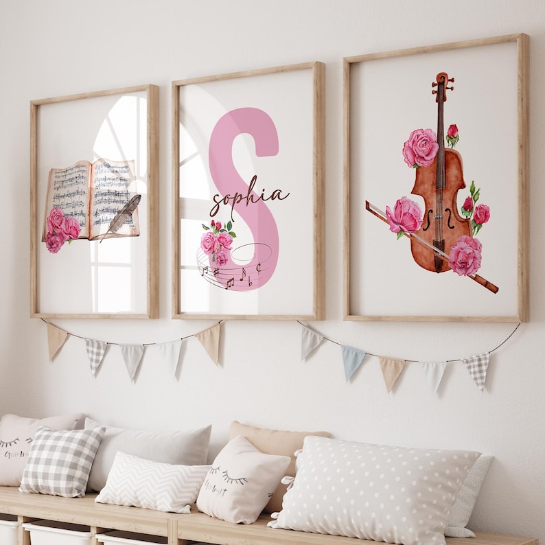 May include: Three framed prints with a musical theme. The first print features a pink letter S with the name "sophia" written below it. The second print features a book with musical notes and a feather. The third print features a violin with pink flowers.