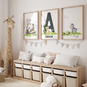 May include: Three framed prints with a safari animal theme. The prints feature a golf cart with an elephant, the letter A with a lion, and a zebra with a golf club. The letter A print has the name Andrew below it.