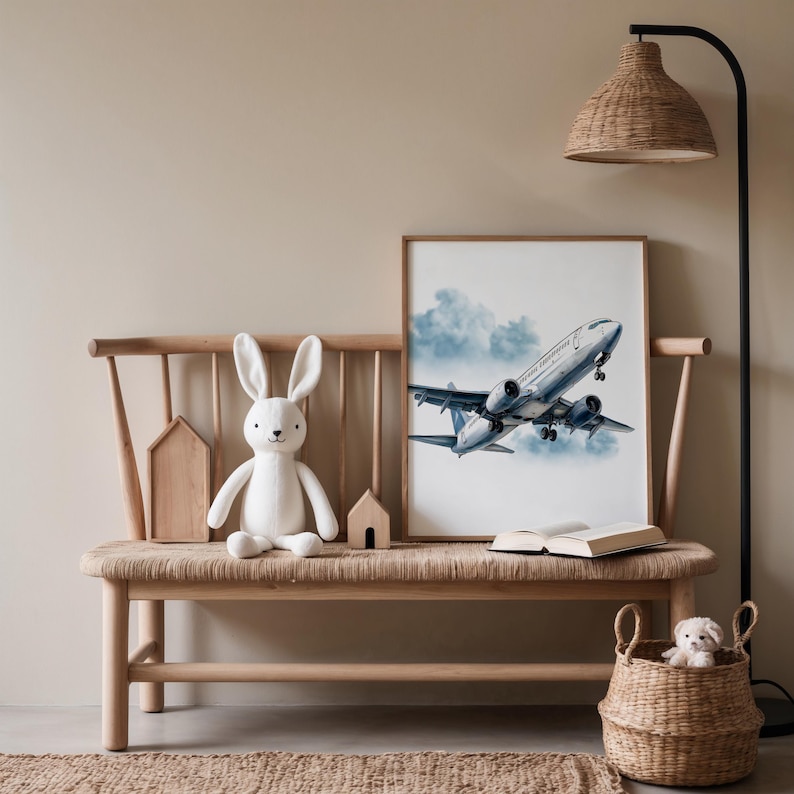 Puede incluir: Una escena interior acogedora con un banco de madera y una impresi&oacute;n enmarcada de un avi&oacute;n azul y blanco despegando. Un conejito de peluche blanco y una peque&ntilde;a cesta con un perro de peluche tambi&eacute;n est&aacute;n presentes.