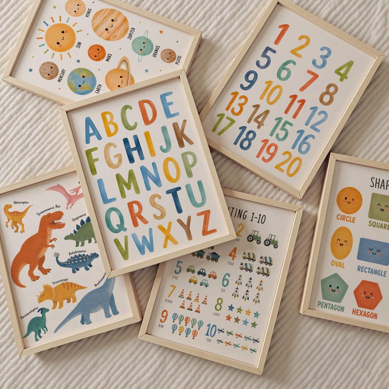 May include: A collection of six framed educational wall art prints featuring watercolor illustrations. The prints display the alphabet, numbers 1-20, numbers 1-10 with icons, various dinosaur species, geometric shapes with faces, and the solar system.