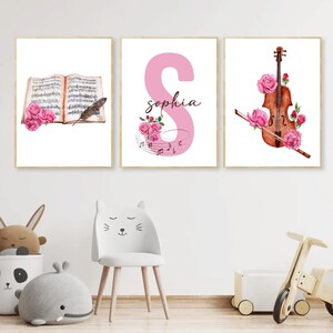 May include: Three printable wall art prints featuring a pink musical note, a violin with pink flowers, and an open music book with a feather. The pink musical note has the name "Sophia" written on it.