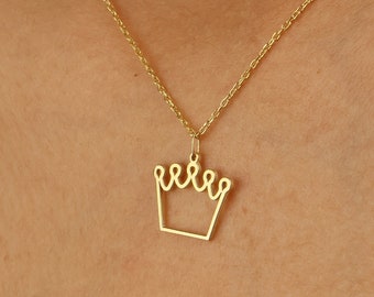 May include: A gold chain necklace with a delicate crown pendant. The crown is a simple outline with five points.