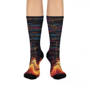 May include: A pair of black socks with a colorful code design. The socks feature a flowing, abstract pattern in shades of orange, yellow, and red at the foot and ankle, with a black toe and heel. The upper portion displays lines of colorful code.