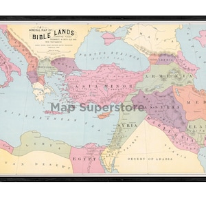 May include: A framed historical map titled A General Map of Bible Lands, featuring pastel-colored regions including Asia Minor, Egypt, and Syria. The map displays geographical labels in black text, surrounded by a dark wood-toned frame border.