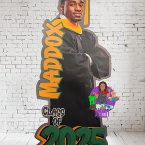 May include: A graduation cutout featuring a person in a black cap and gown with a gold stole. The cutout includes the name "MADDOX" in orange and green, and "CLASS OF 2025" in green and orange. A small cartoon graphic is in the lower right corner.