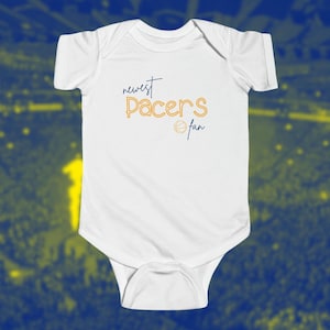 May include: White baby onesie with the text "newest Pacers fan" in yellow and a basketball graphic.
