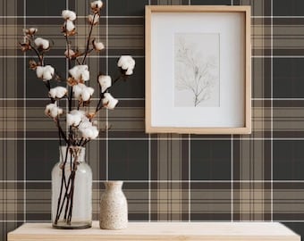 May include: A wooden shelf displays a clear glass vase with cotton stems, a small speckled vase, and a framed picture. The background is a plaid wallpaper in shades of brown, gray, and white. The framed picture has a light wood frame.