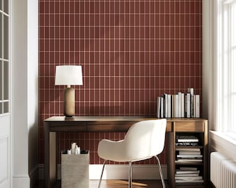 May include: A dark wood desk with a built-in side shelf and a drawer, paired with a cream-colored upholstered chair. A table lamp with a white shade sits on the desk, which is set against a wall with a terracotta-colored grid pattern wallpaper.