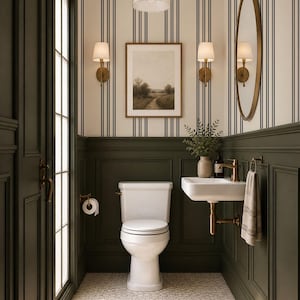 May include: A bathroom interior featuring dark green wainscoting, cream and black striped wallpaper, and a white toilet. A wall-mounted white sink with brass hardware, a round mirror, two wall sconces, a pendant light, and framed landscape art.