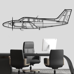 May include: A black metal airplane wall decor in a modern office setting with a black desk and three black office chairs.