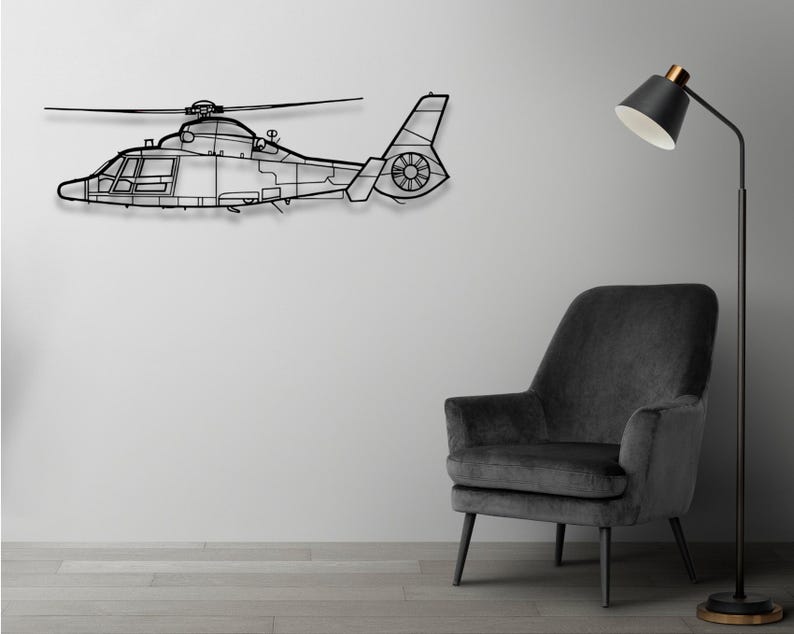 Peut inclure: Une silhouette noire en m&eacute;tal d'un h&eacute;licopt&egrave;re mont&eacute;e sur un mur blanc. Un fauteuil noir avec un rev&ecirc;tement en tissu gris est plac&eacute; devant un lampadaire noir avec un abat-jour blanc.